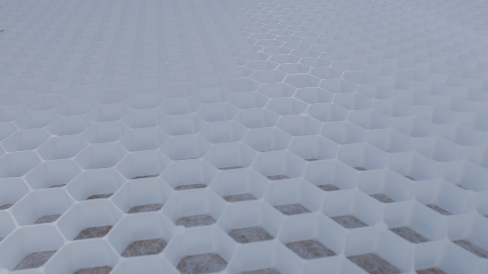 Close-up of CORE DRIVE honeycomb grid interlocking system during gravel driveway installation.