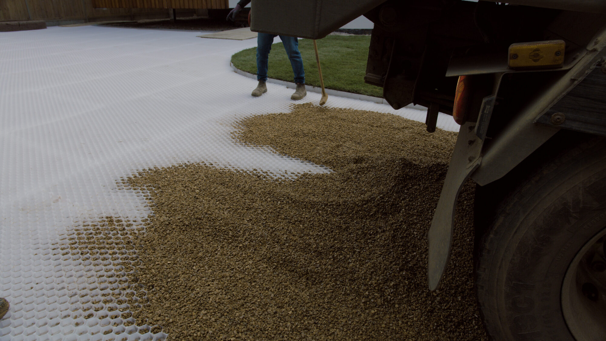 Filling CORE DRIVE stabilisation grid with angular gravel for a secure, rut-free driveway surface.